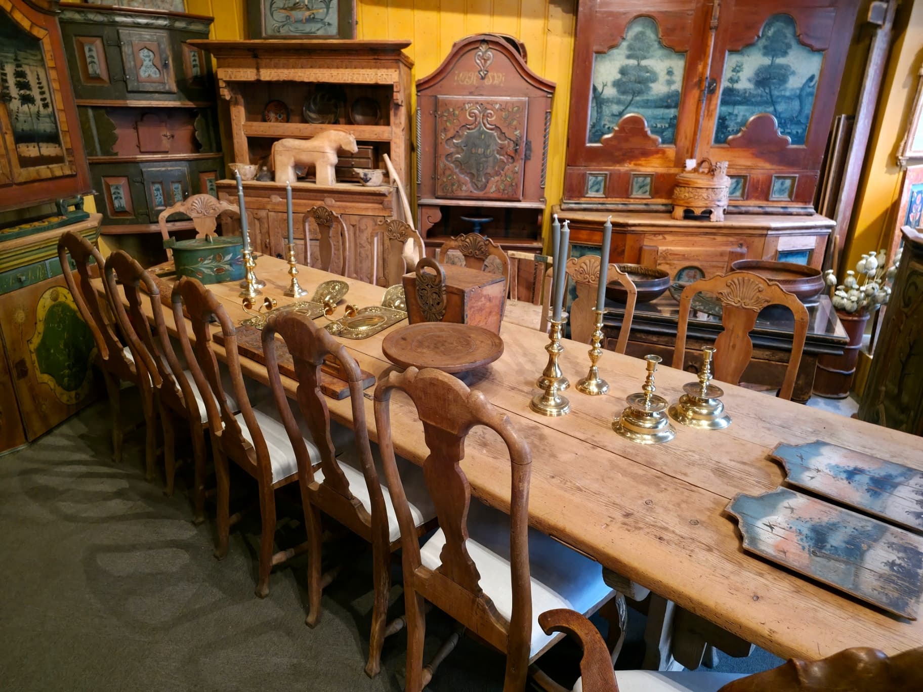 Langbord og rosemalte skap i butikken på Kirkeveien